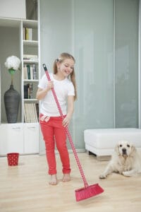 young girl sweeping the floor