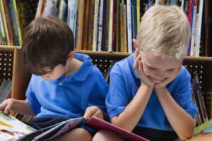 picture of 2 boys at library reading books in the summer