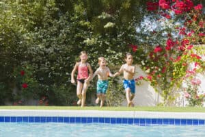 picture of kids jumping into a pool in the summer