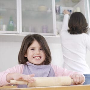 picture of a young girl baking with her mother as a fun indoor activity