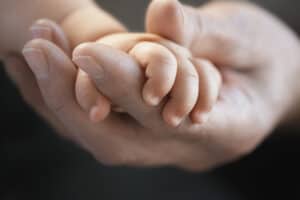 mother holding toddlers hands