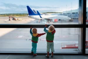 toddlers at an airport with airplane background