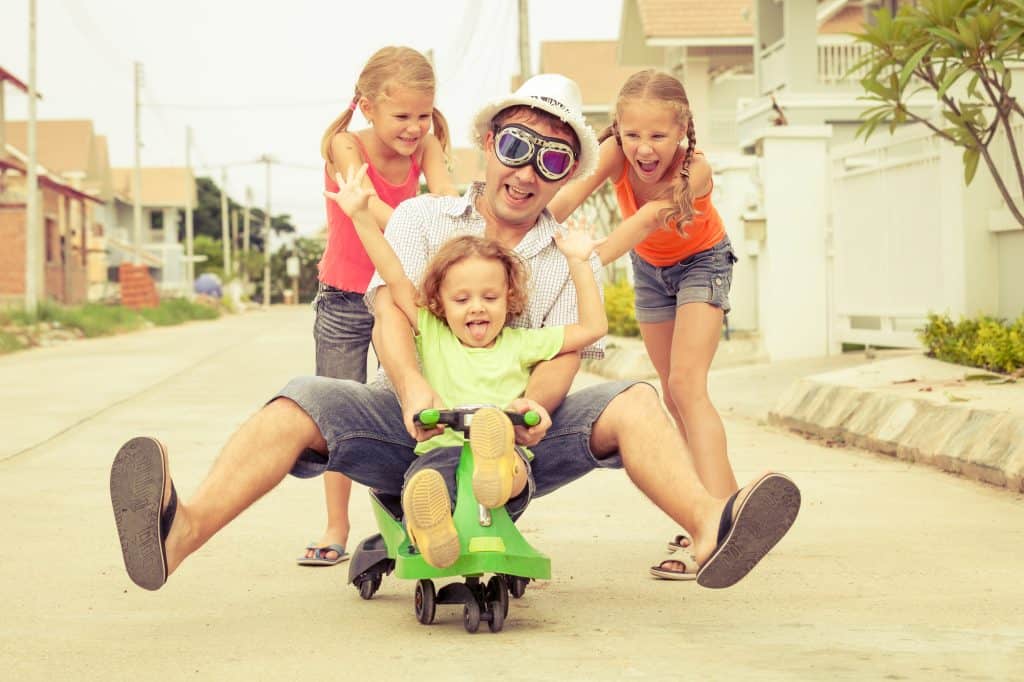 father and children playing near a house at the day time
