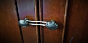 picture of a rubber band on a set of cabinet door handles to provide baby proofing
