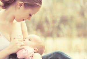 picture of a woman breastfeeding her teething baby