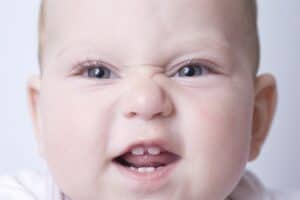 picture of a teething baby showing off their teeth for the camera