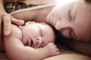 picture of a new mom sleeping with newborn baby
