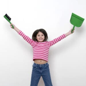 picture of a young girl holding a dust pan and small broom ready to help with household chores