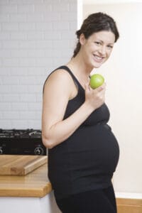 picture of a pregnant woman eating an apple