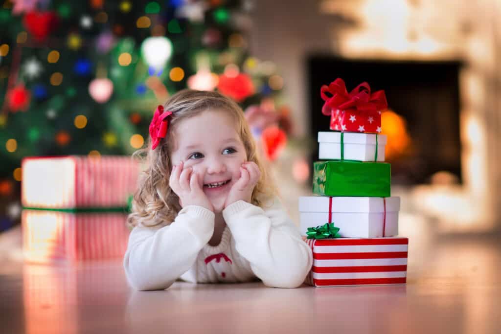 toddler smiling waiting to open Christmas presents