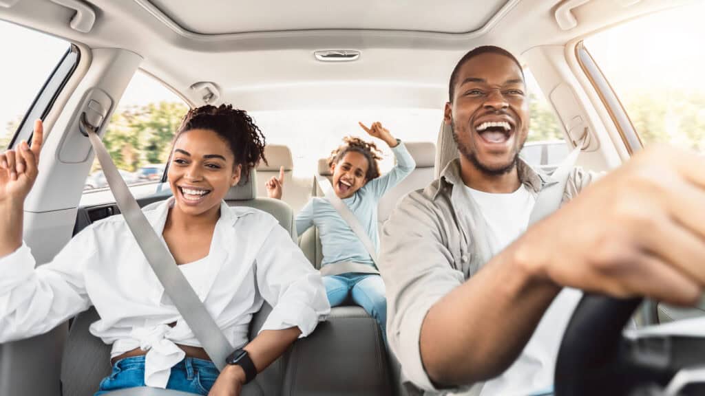 picture of a family riding in a car singing while on a family road trip