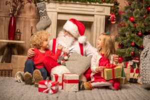 picture of two children sitting with Santa on Christmas Eve