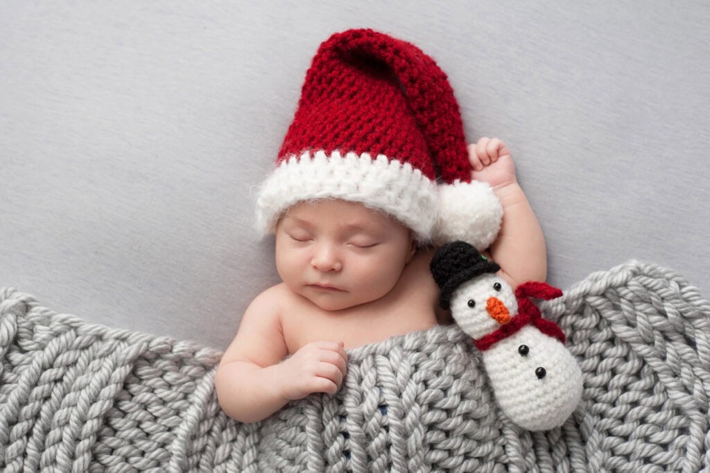 baby sleeping in a Santa hat for baby's first Christmas