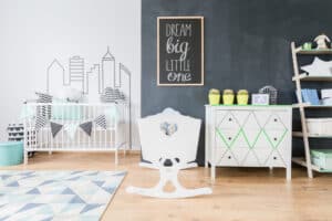 picture of a minimalist nursery with a crib, dresser and shelf