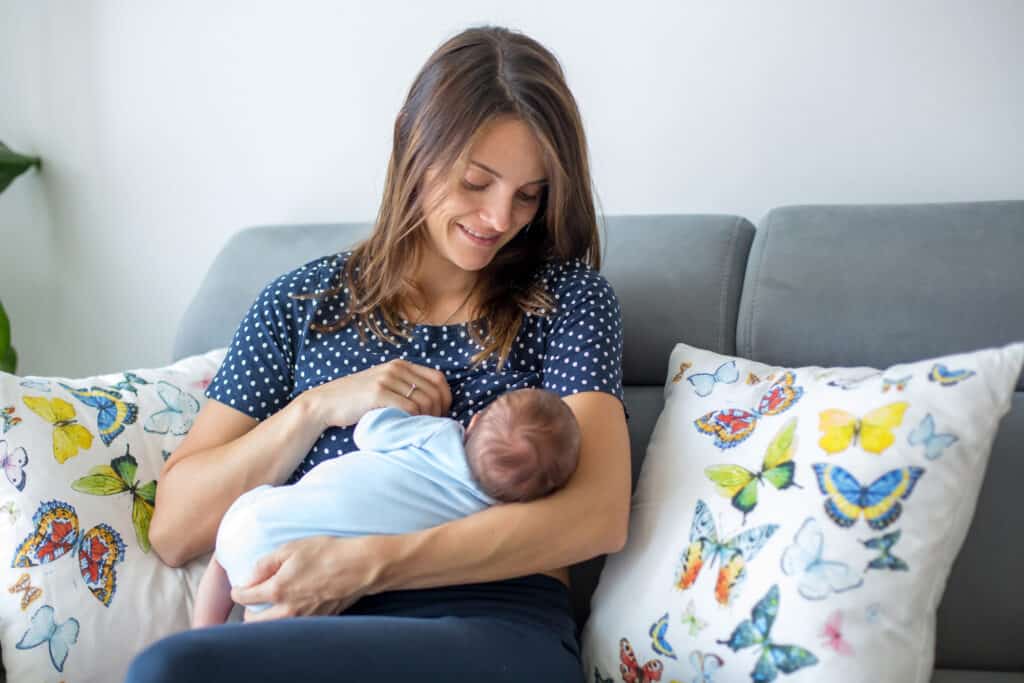 woman in cute breastfeeding shirt nursing newborn baby