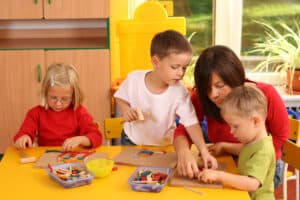 3 year old learning activity with other children and a teachers