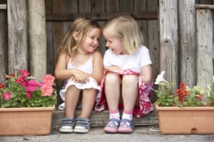 picture of two toddlers girls sitting together talking