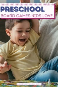 picture of a preschool-aged boy lying on his mother's lap smiling while playing a preschool board game