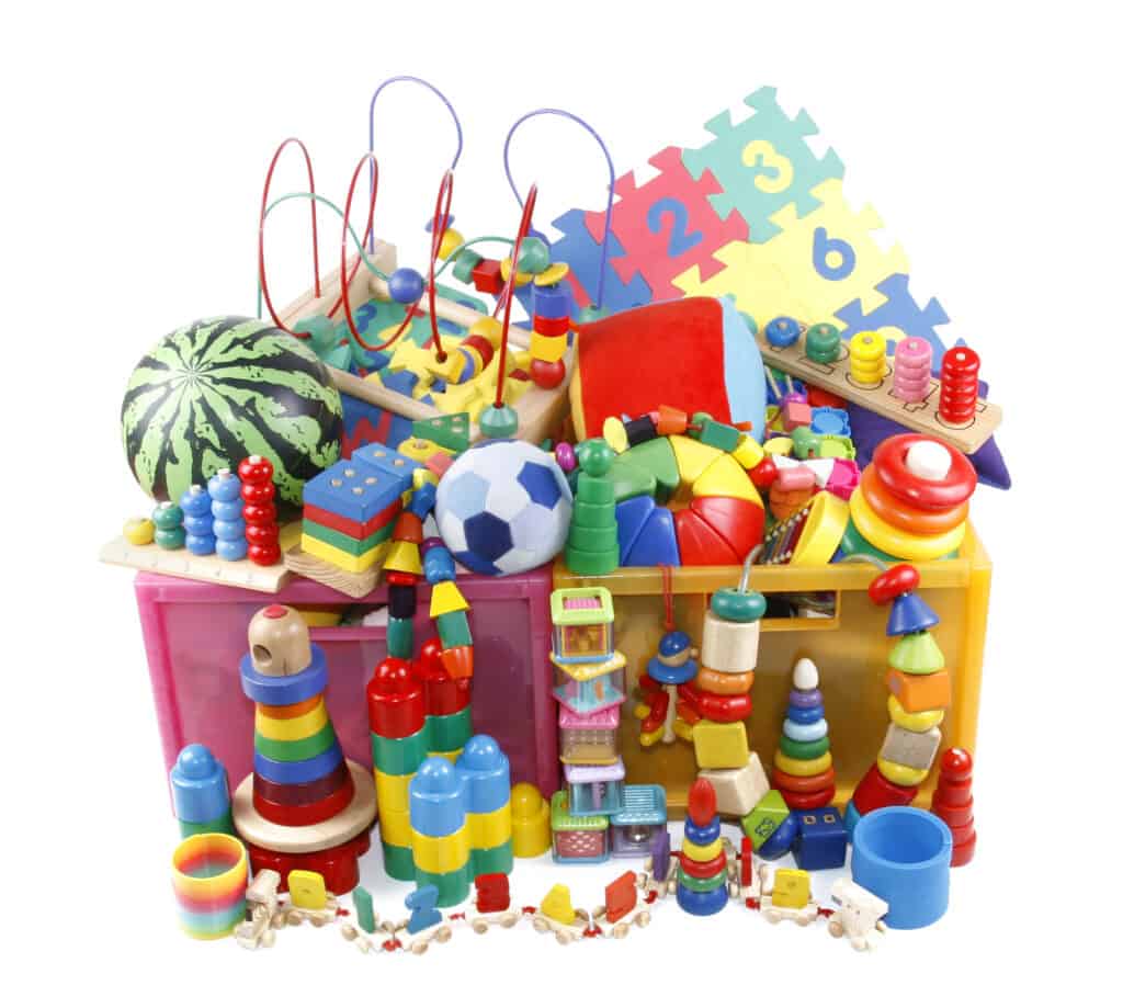 picture of a pile of all different kids toys like foam blocks, balls, stacking toys, play mats, building blocks and more that need some cheap toy storage ideas