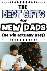 Pinterest pin with the text, "The Best Gifts for New Dads He Will Actually Use", with a picture of a new dad holding his newborn baby in front of a Christmas tree