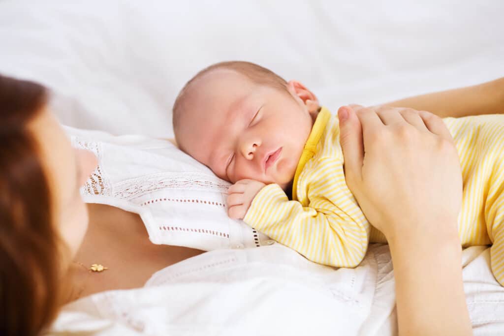 picture of a new mom wearing pajamas holding her baby