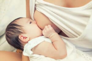 woman breastfeeding her baby in the cross cradle hold