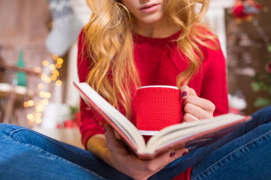 woman with a coffee mug reading one of the best Christian parenting books