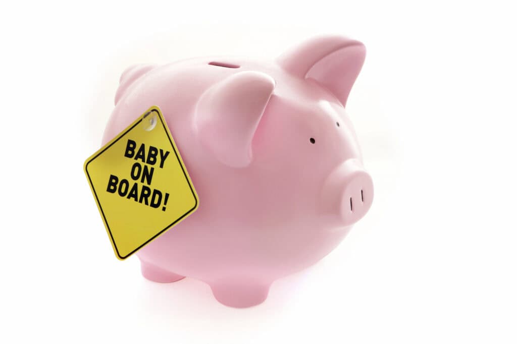 pink piggy bank with a baby on board sign