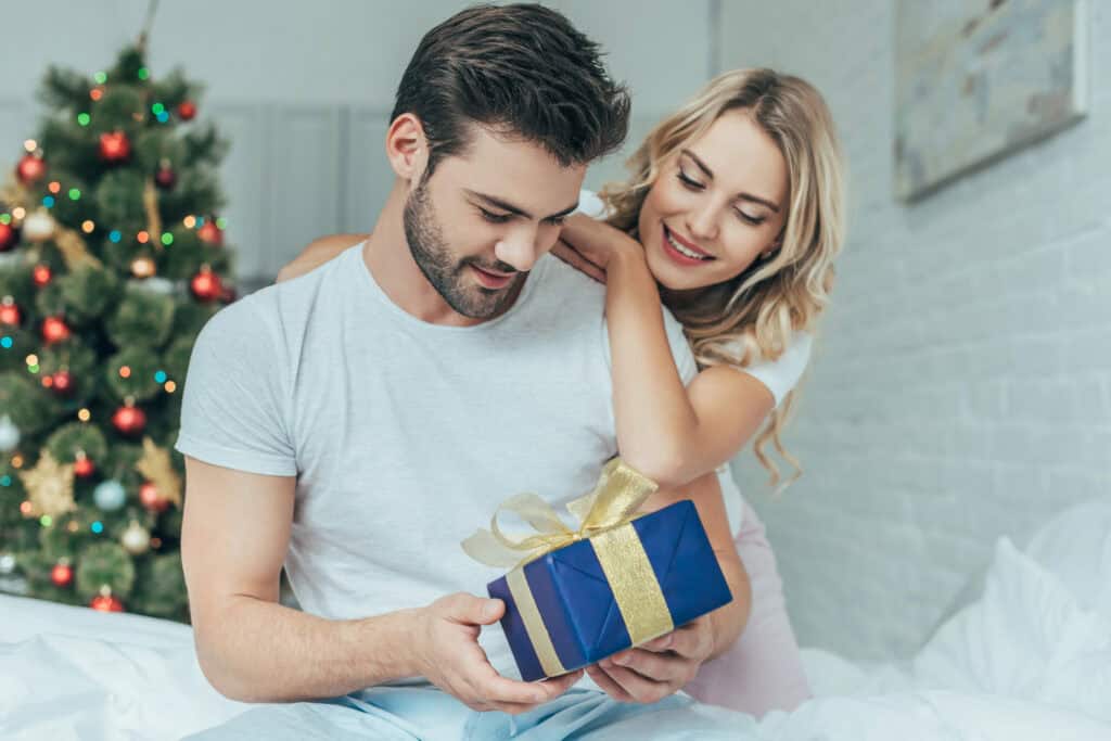woman giving her husband a Christmas gift