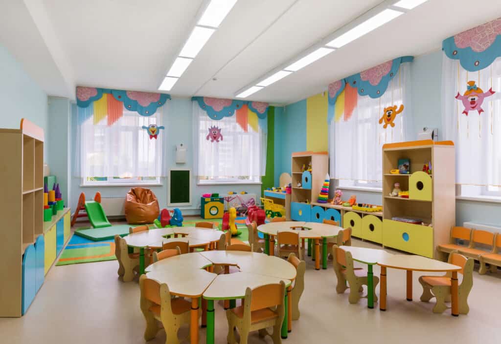picture of a Kindergarten classroom with tables and classroom supplies and decorations