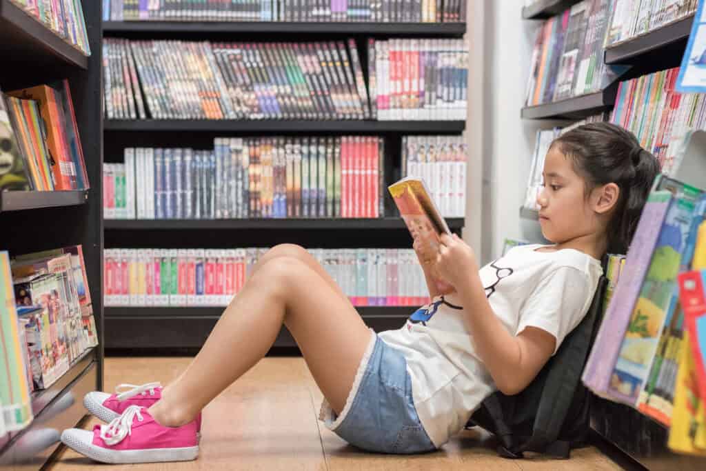 picture of a girl sitting in a bookstore reading a Christian picture book for kids