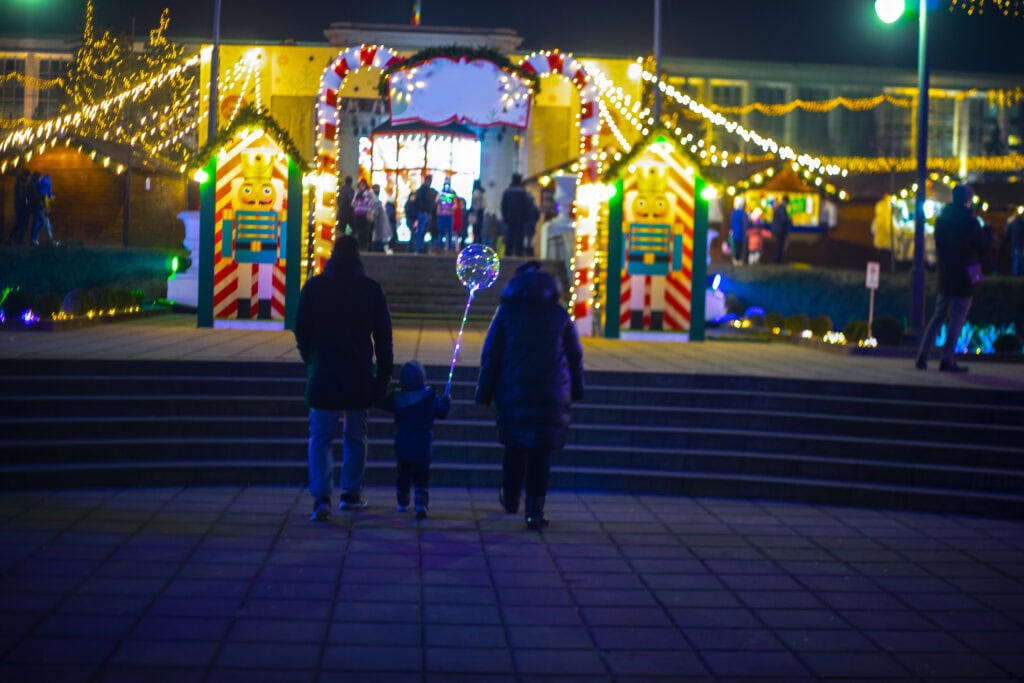 picture of a family walking to see a Christmas light display as part of their Christmas bucket list for kids