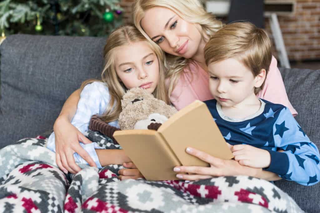 picture of a mother with her kids sitting on a couch reading a family Advent devotional