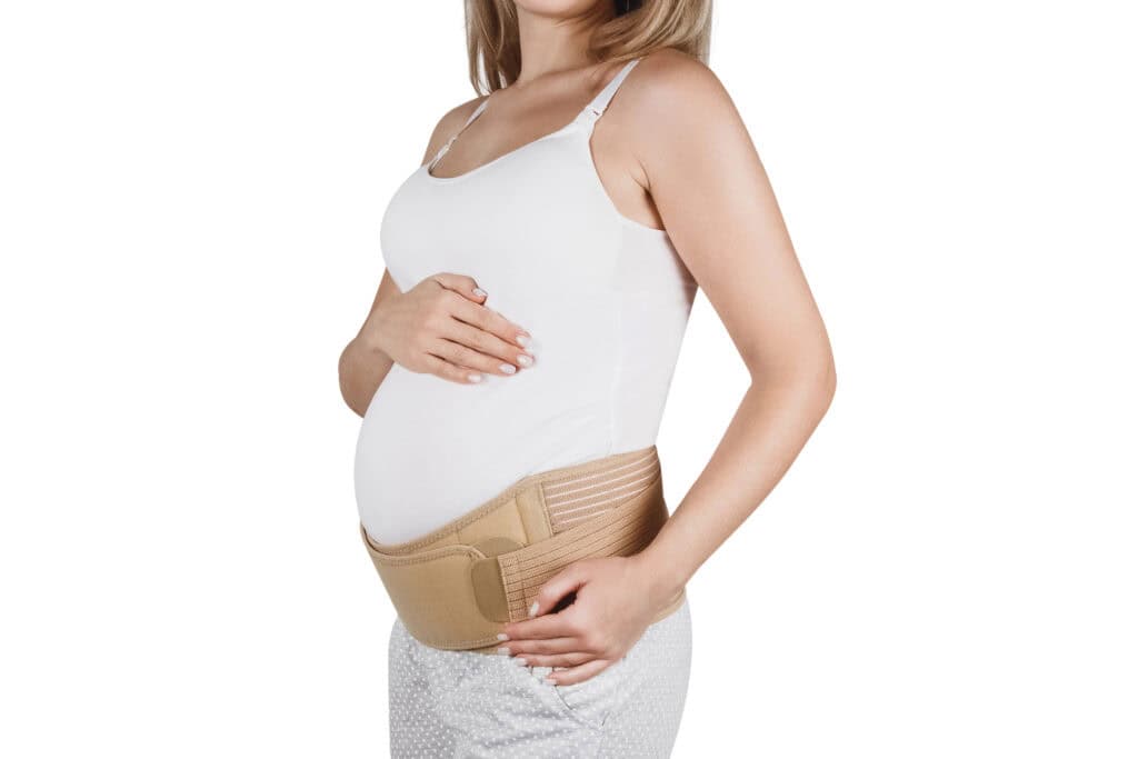 pregnant woman wearing a a belly band around her pregnant belly for support